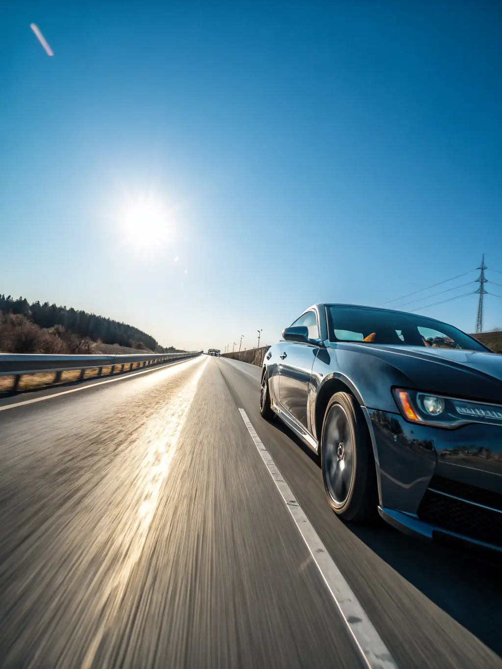 A sleek, modern car driving on a sunny highway, symbolizing freedom and security with Key Agency's vehicle insurance.